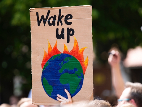 En klimademonstrant holder et alarmistisk skilt med en opfordring til verdens politikere om at "vågne op". (Foto: Markus Spiske/Unsplash)